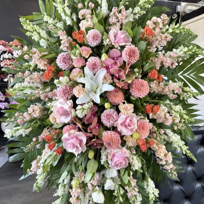 Blooming Memories Funeral Spray, a luxury floral tribute with pink roses, dahlias, and white lilies in an elegant arrangement.