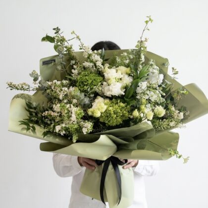 Bella Signora - Wrapped Bouquet featuring lush green hydrangeas, delicate white roses, and fragrant eucalyptus, elegantly arranged.