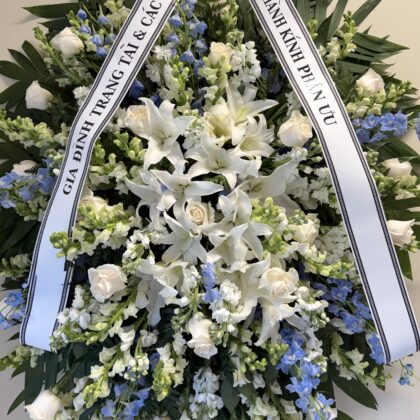 Eternal Love - Funeral Spray featuring white lilies, roses, and blue delphiniums as a Peaceful Floral Tribute.