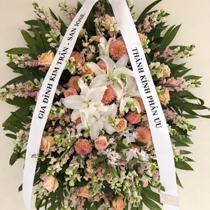 A luxurious floral arrangement featuring white lilies, soft pink roses, and vibrant dahlias, elegantly styled.