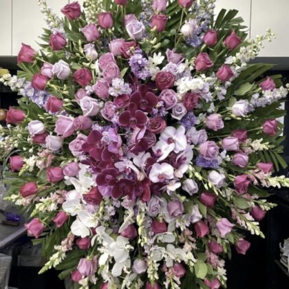 Peaceful Orchids Funeral Spray - Magnificent Tribute featuring deep purple orchids, lavender roses, and white accents.