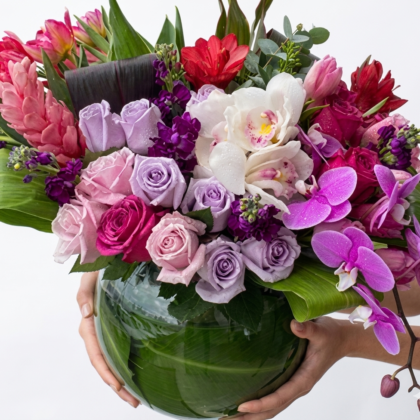 Cielo Di Notte - Vase filled with elegant pink and purple roses, orchids, and vibrant tropical flowers.