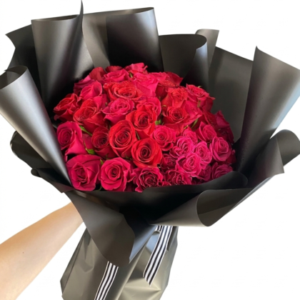 Amore Infinito - Wrapped Bouquet featuring vibrant pink roses elegantly arranged in luxurious black wrapping.