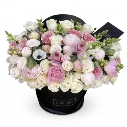 Luxurious floral arrangement featuring soft pink peonies, white roses, and delicate orchids in an elegant black hat box.