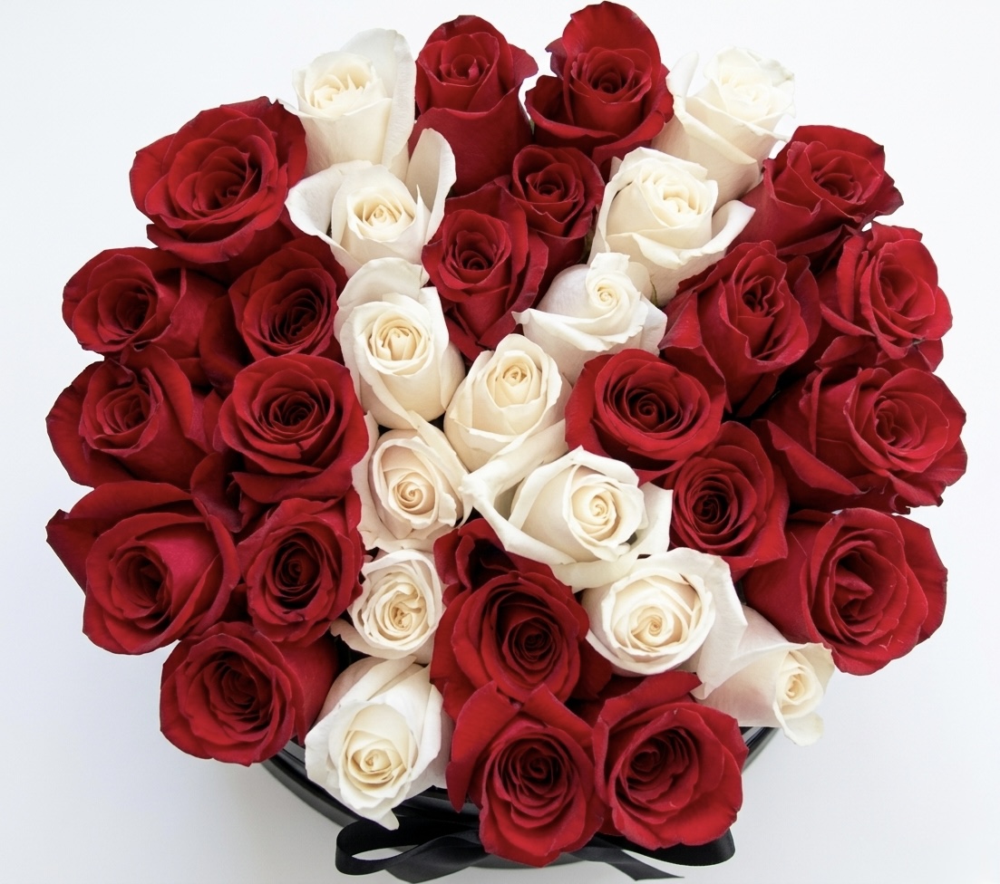 An elegant arrangement of deep red and creamy white roses, beautifully crafted for a luxurious touch.