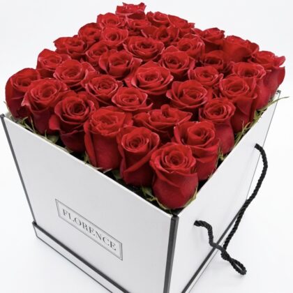 Luxurious arrangement of vibrant red roses in a sleek white box, exuding elegance and romance.