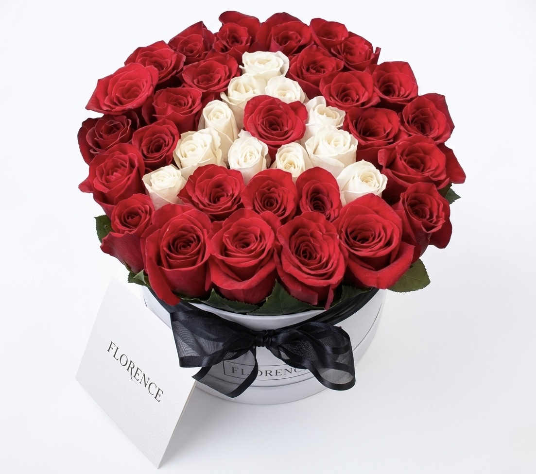 Elegant arrangement of red and white roses in a luxurious round box, perfect for special occasions.