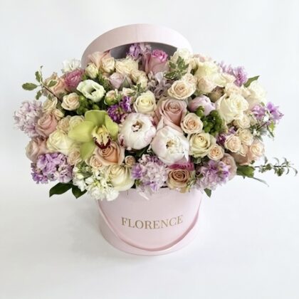 Luxurious arrangement of soft pink and lavender roses, complemented by delicate lilacs and green accents.