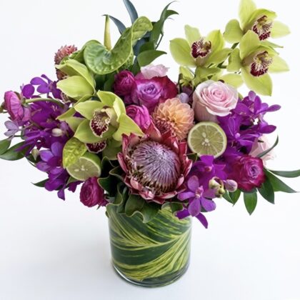 Wild Tropicana - Vase features vibrant orchids, lush greens, and rich pink roses in an elegant arrangement.