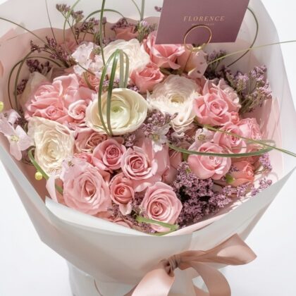 Flirt Alert - Wrapped Bouquet featuring soft pink roses, white ranunculus, and delicate lavender accents elegantly arranged.