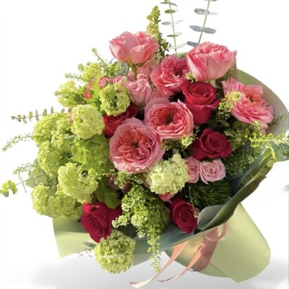 Bacio Di Sole - Wrapped Bouquet featuring lush pink roses, delicate green hydrangeas, and elegant greenery.