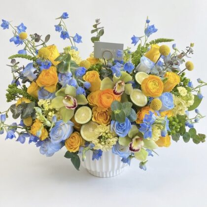Capri Amore - Ceramic Vase filled with vibrant yellow and blue flowers, elegantly arranged with greenery.