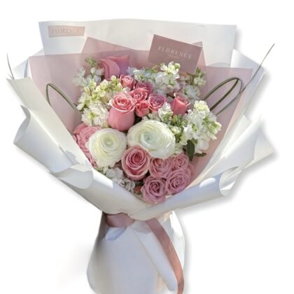 Rivieria Rosa - Wrapped Bouquet featuring soft pink roses, white ranunculus, and delicate greenery, elegantly arranged.