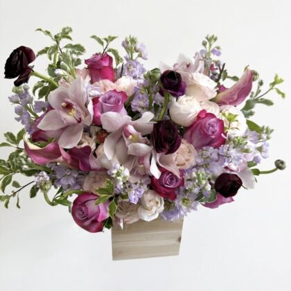 Fiore Segreto - Wood Pot featuring an elegant arrangement of pink and purple roses, orchids, and delicate greenery.