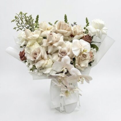 Cascading Moon - Wrapped Vase featuring elegant white and soft beige roses with delicate orchids.