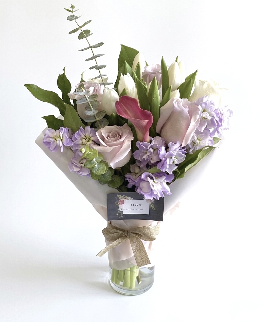Carina Stella - Wrapped Vase featuring elegant pastel roses, tulips, and lilacs in a sophisticated arrangement.
