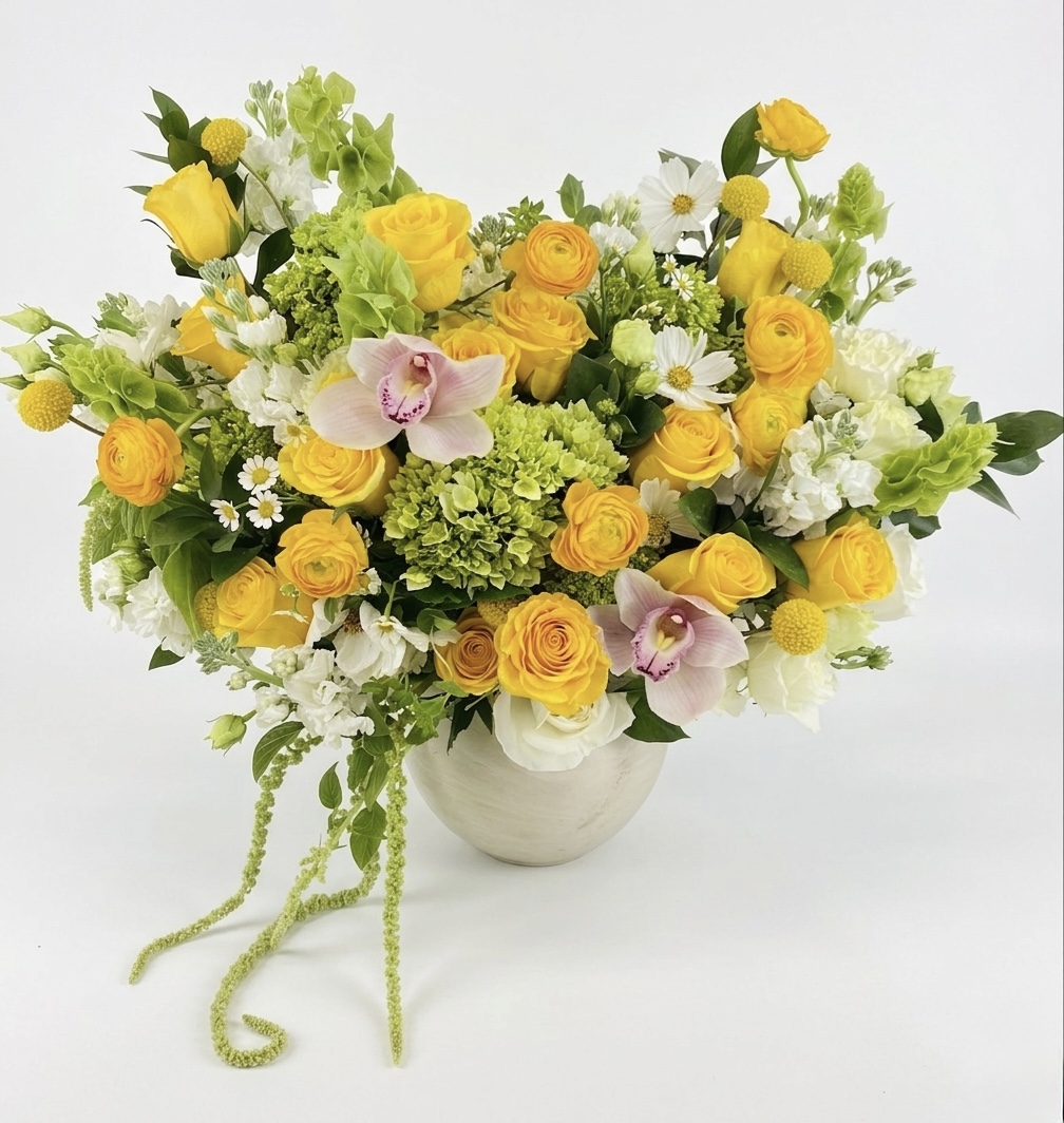 Luxurious arrangement of yellow roses, green hydrangeas, and delicate orchids in a premium vase.
