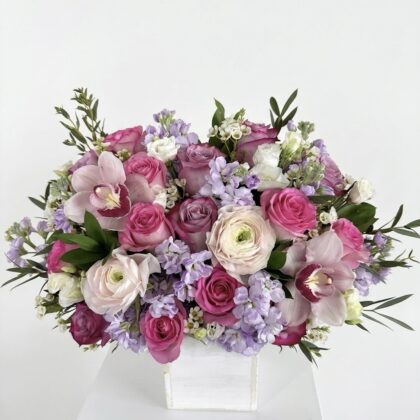 Luxurious arrangement of pink roses, delicate lilacs, and elegant orchids in a premium white box.