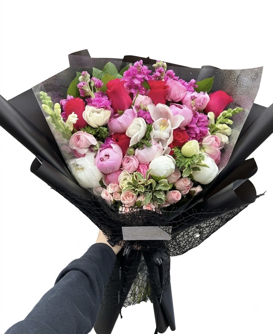 An elegant bouquet featuring vibrant pink roses, delicate peonies, and lush greenery, beautifully arranged.