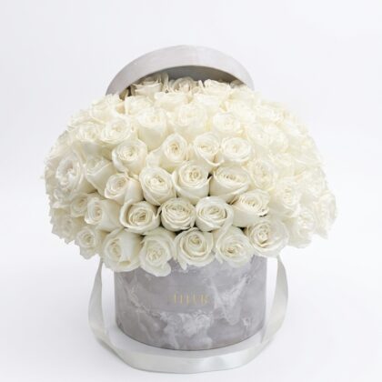R&ecirc;ve Blanc flower box featuring a dense arrangement of Elegant All White Roses in a marble-patterned round container.