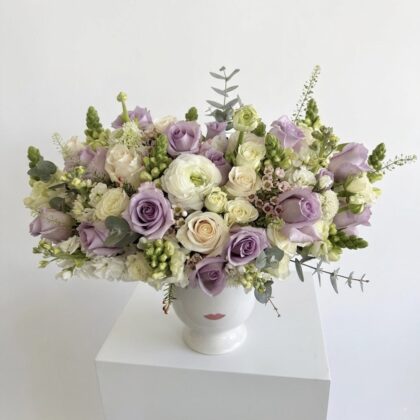 Lavender L'amour Ceramic Vase for Whimsical Elegance featuring lavender roses and white ranunculus in a lip-print vase.