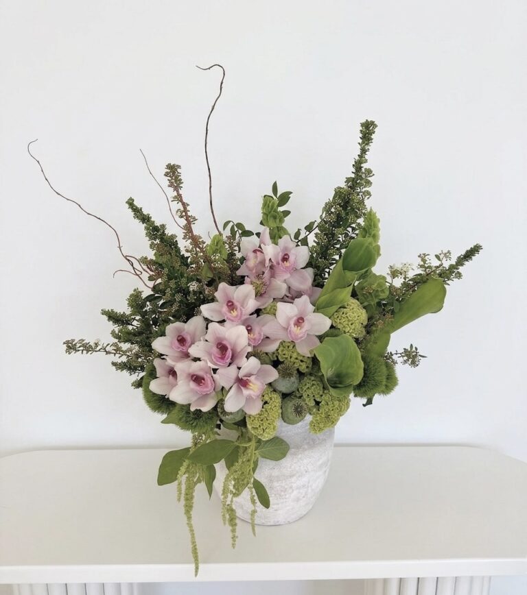 Matisse Meadow &ndash; Avant-Garde Ceramic Vase featuring pale pink orchids and lush green foliage in a textured stone vessel.