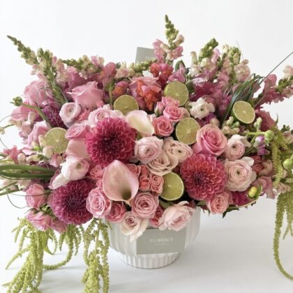 Ciao Bella – Avant-Garde Ceramic Vase featuring a lush arrangement of pink dahlias, roses, and cascading green amaranth.