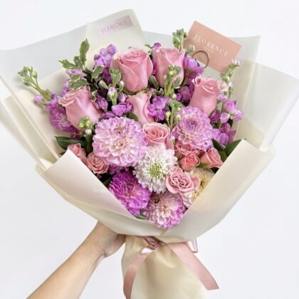 Bella Luna Rose – Luxury Wrapped Bouquet featuring pink roses and purple dahlias in elegant cream paper.