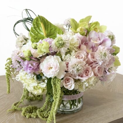 Merci Beaucoup – Modern Luxury Vase Arrangement featuring pastel roses, orchids, and green anthurium in a glass vase.