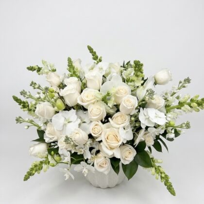 Timeless Ceil De Vanille Ceramic Vase filled with an elegant, lush arrangement of white roses, orchids, and snapdragons.