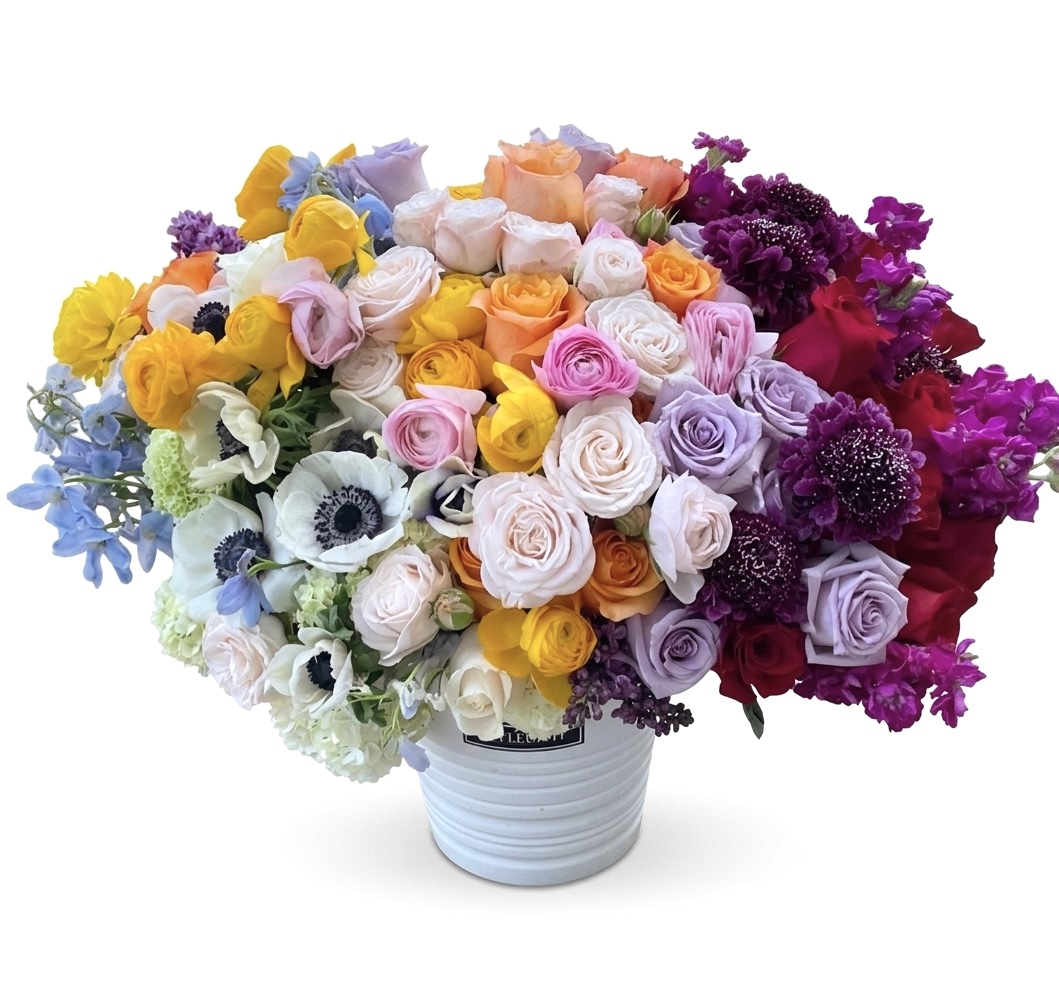 La Vie En Fleur – Stunning Ceramic Vase featuring a vibrant, dense arrangement of multicolored roses, anemones, and stock.