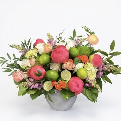 Mon Cher Tresor – Vibrant Concrete Vase featuring pink peonies, orange roses, and fresh lime accents in a gray vessel.