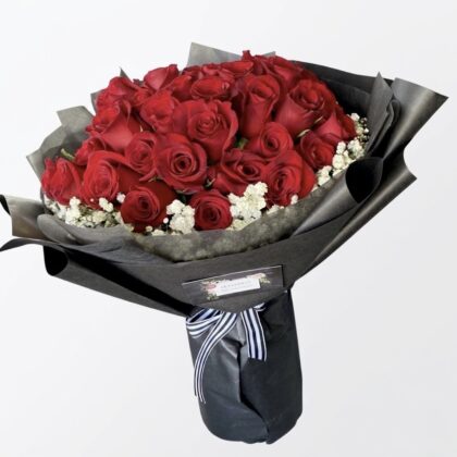 Promenade De Rose – Wrapped Bouquet featuring deep red roses and white baby's breath in elegant black paper.