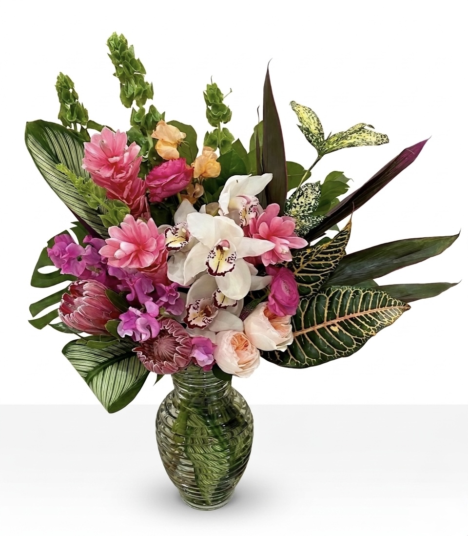 Tropical Luxury L'Exotique Vase Centerpiece featuring pink ginger, white orchids, and lush foliage in a glass vase.