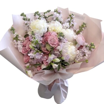 Haute Couture - Wrapped Bouquet featuring white peonies, pink roses, and lilac stock flowers in elegant paper.