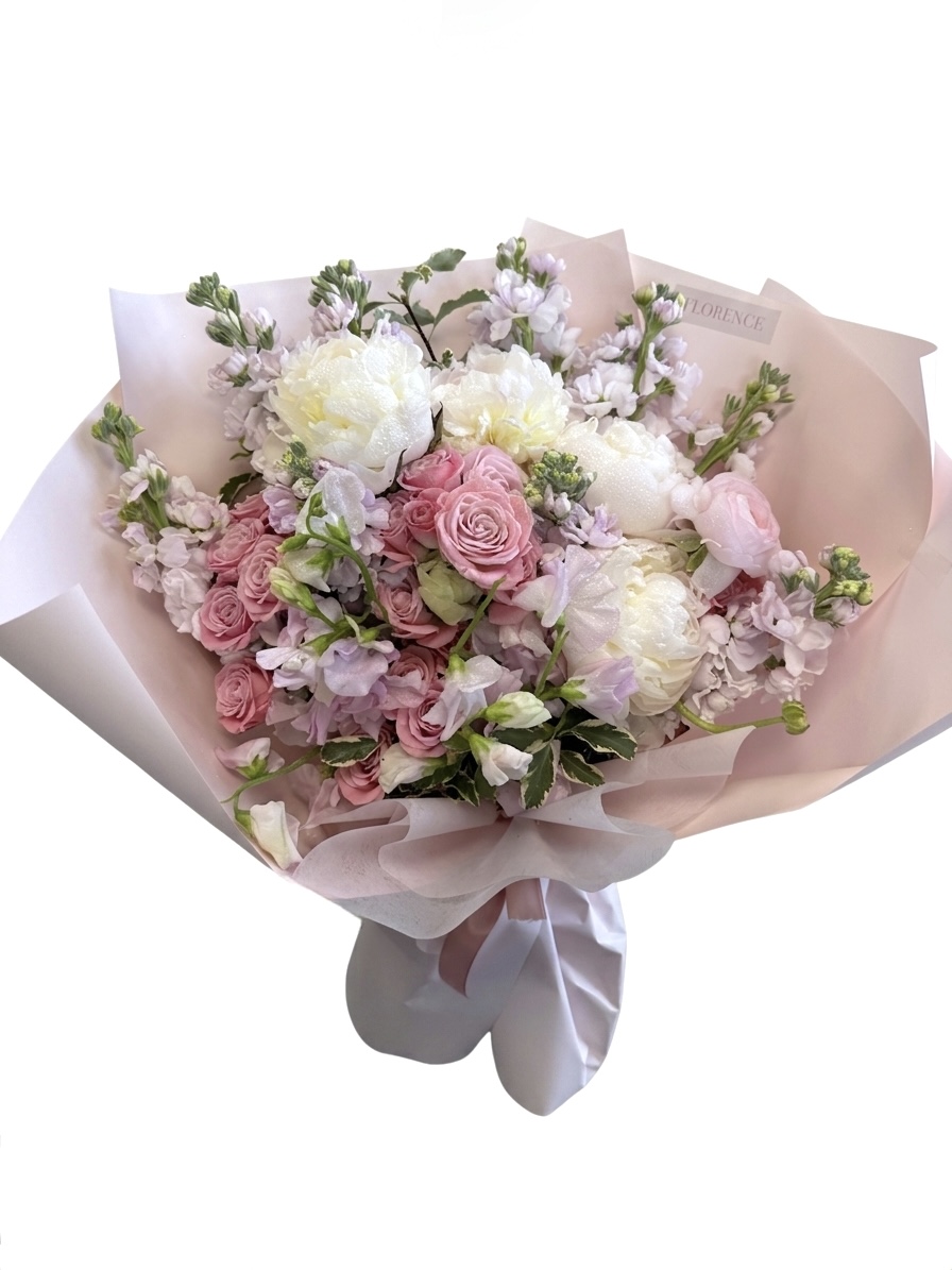 Haute Couture - Wrapped Bouquet featuring white peonies, pink roses, and lilac stock flowers in elegant paper.