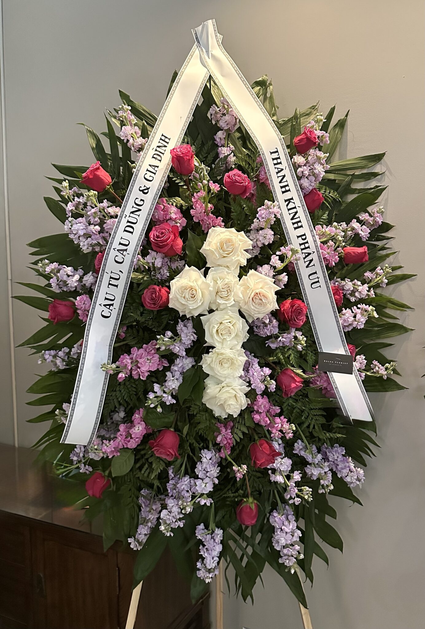 Time After Time Elegant Floral Cross Funeral Spray featuring white roses, pink roses, and lavender stock flowers.