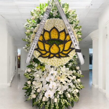 Melrose Abbey Double Layer Lotus Funeral Spray featuring white chrysanthemums, lilies, and orchids with a yellow lotus design.