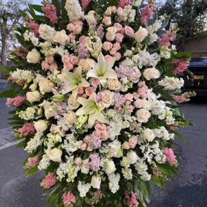 The Afterlife Funeral Spray - Comforting Floral Tribute featuring white lilies, blush roses, and pink snapdragons.
