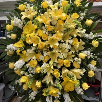 Golden Hour Funeral Spray - Radiant Floral Arrangement featuring yellow roses, lilies, and white stock flowers.