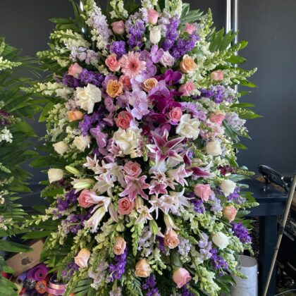 Lavender Melody – Double Layer Funeral Spray featuring lush purple, pink, and white blooms in an elegant vertical design.