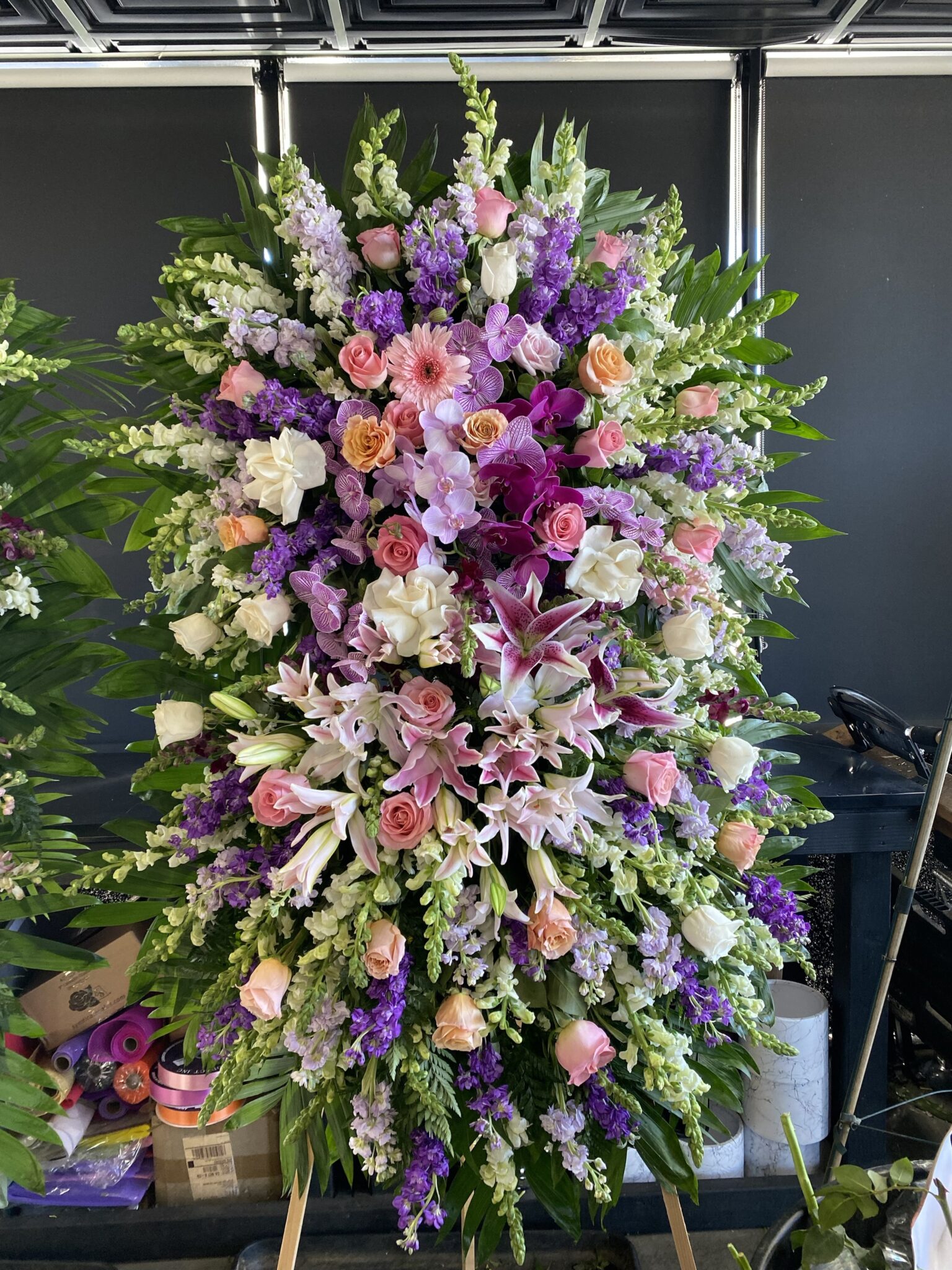 Lavender Melody – Double Layer Funeral Spray featuring lush purple, pink, and white blooms in an elegant vertical design.