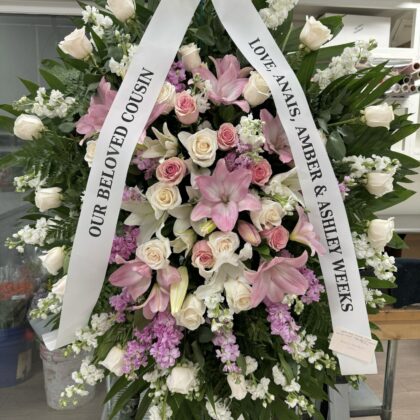 Sunbeam Sympathy – Elegant Funeral Spray featuring white roses, pink lilies, and lavender stock flowers on a stand.