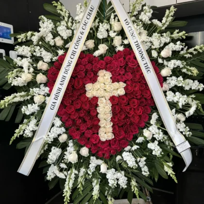 Infinite Heart Cross – Elegant Funeral Spray featuring deep red roses, white roses, and white snapdragons.