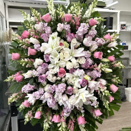 Botanical Memories Funeral Spray - Elegant Design featuring pink roses, white lilies, and lavender stock flowers.