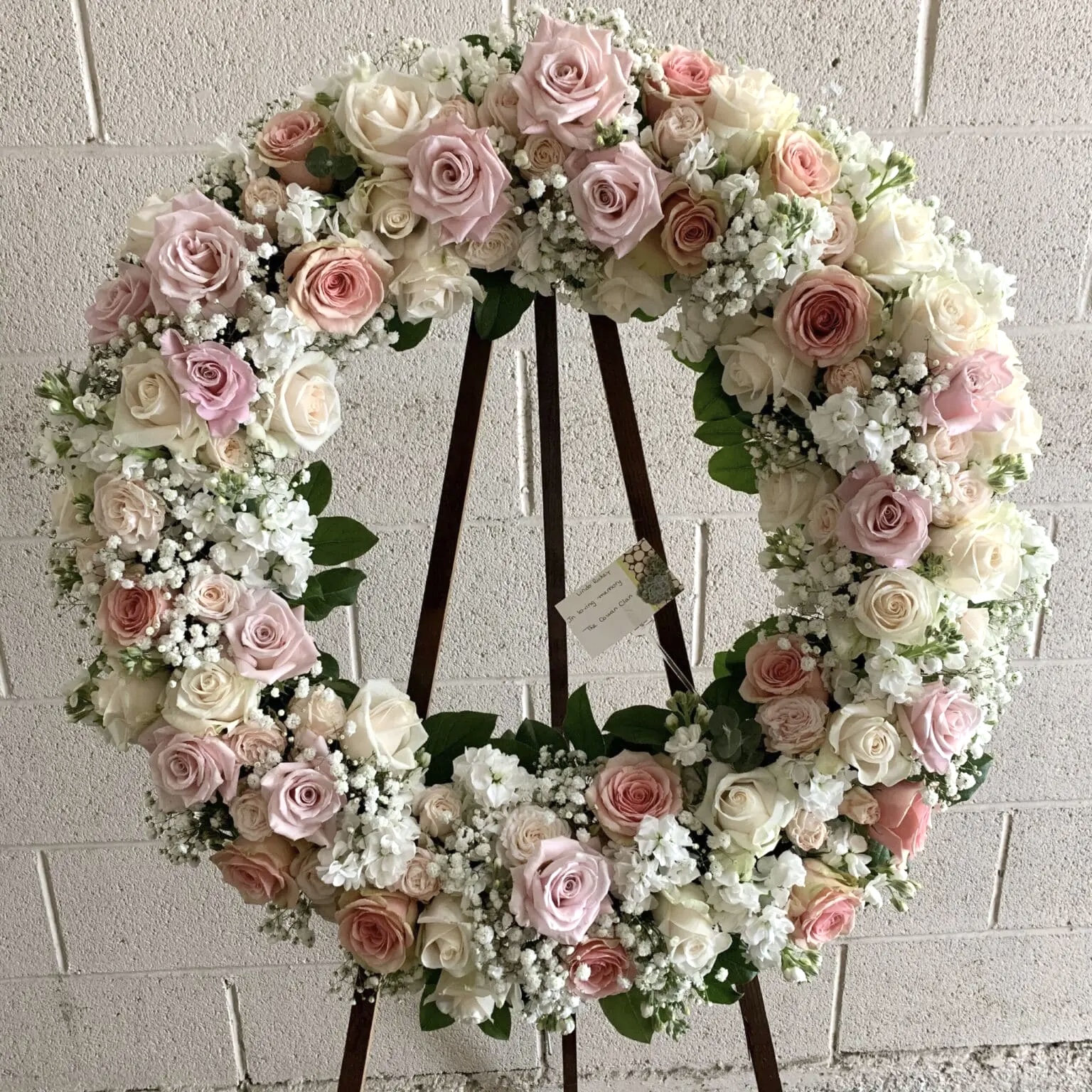 Gentle Journey Wreath - Elegant Funeral Tribute featuring soft pink and cream roses with delicate white baby's breath.