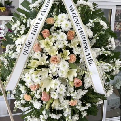 Loving Embrace Funeral Spray – Heartfelt Floral Design featuring white lilies, chrysanthemums, and soft peach roses.