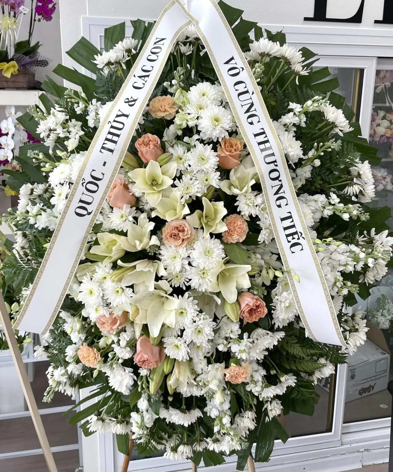 Loving Embrace Funeral Spray – Heartfelt Floral Design featuring white lilies, chrysanthemums, and soft peach roses.
