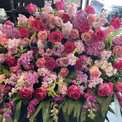 Velvet Petals Casket Spray - Lush Floral Design featuring vibrant pink and soft lavender roses and stock flowers.