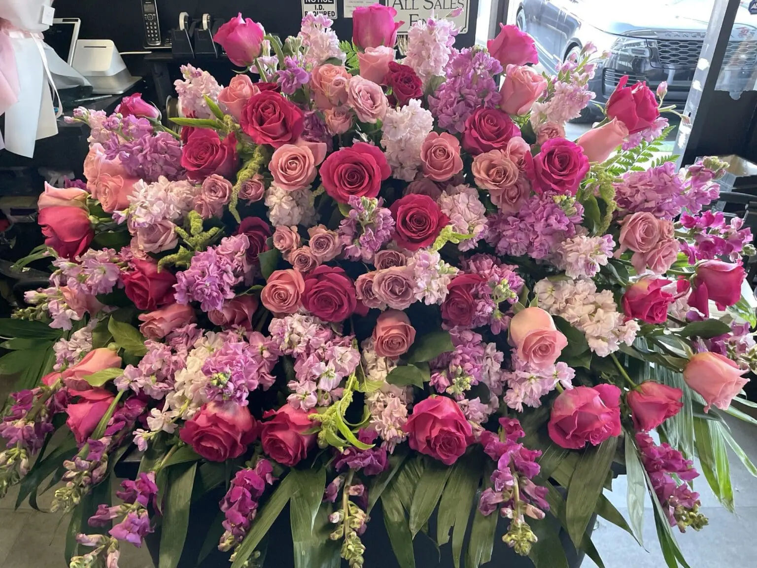 Velvet Petals Casket Spray - Lush Floral Design featuring vibrant pink and soft lavender roses and stock flowers.